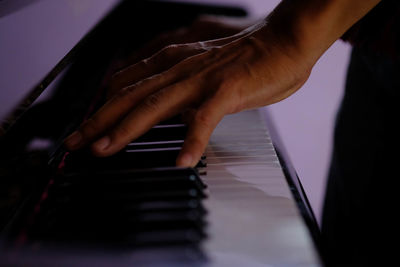 Cropped hand playing piano