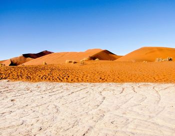 Scenic view of desert against clear blue sky