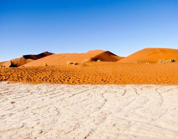 Scenic view of desert against clear blue sky