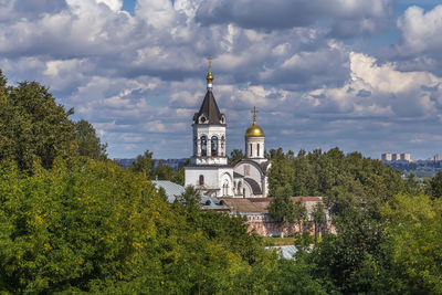 View of trees and building against sky