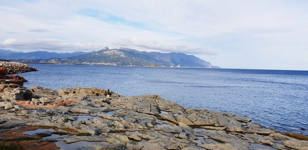 Scenic view of sea and mountains against sky