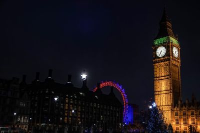 Illuminated clock tower at night