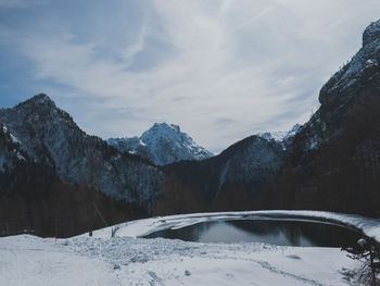 Pond against snow covered mountains