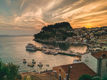 High angle view of boats at harbor in city against sky during sunset