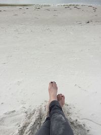 Low section of man standing on beach