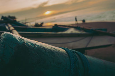 Low section of man on beach against sky during sunset