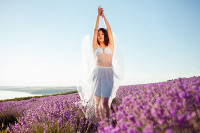 A beautiful young girl against the sunset and a beautiful sky in a lavender field. 