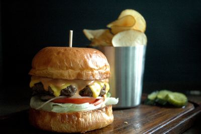 Close-up of hamburger by potato chips on table