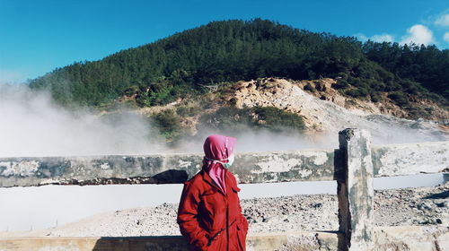 Rear view of man standing against mountain