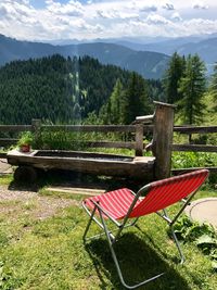 Chairs on landscape against mountains