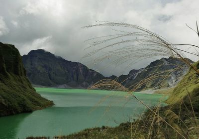 Scenic view of lake and mountains against cloudy sky