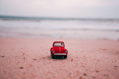 Red toy car on beach