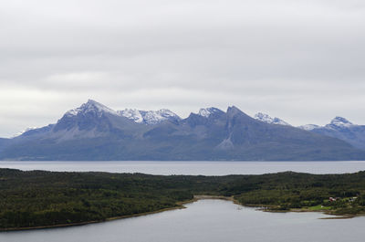 Scenic view of lake by mountains against sky