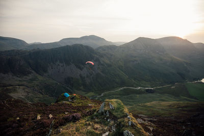 Scenic view of mountains against sky with paraglider