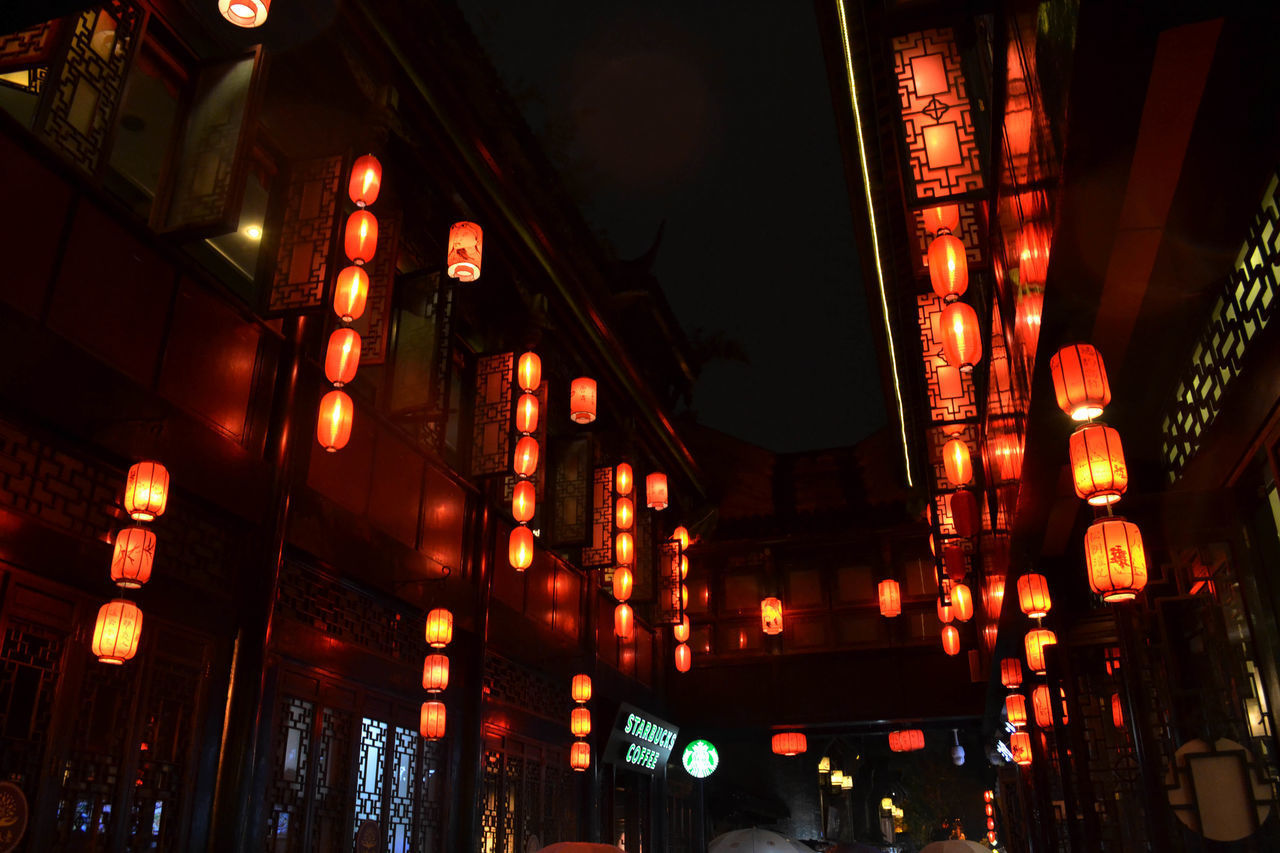 LOW ANGLE VIEW OF ILLUMINATED LANTERNS HANGING IN BUILDING