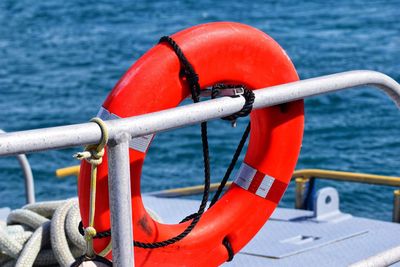 Close-up of rope tied to railing against sea