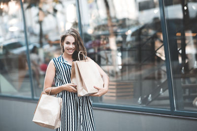 Portrait of young woman holding shopping bags