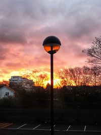 Street light against orange sky