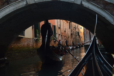 People in gondola by footbridge on canal