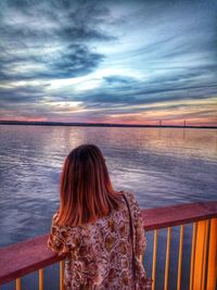 Rear view of woman looking at sea against sky