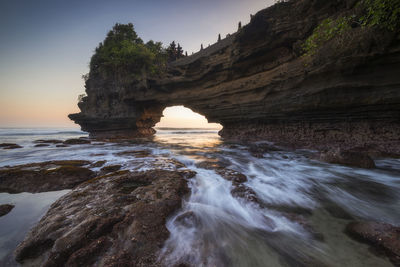 Rock formation in sea against sky