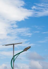 Low angle view of bird perching on pole against sky