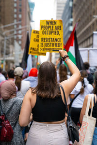 Rear view of people walking on street in city