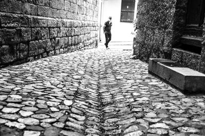 Man walking on cobblestone street