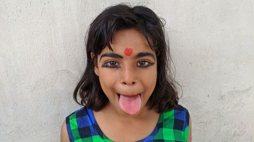 Portrait of smiling girl against wall