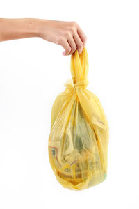Close-up of hand holding apple against white background