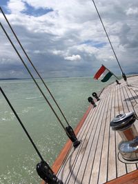 Boats in sea against cloudy sky