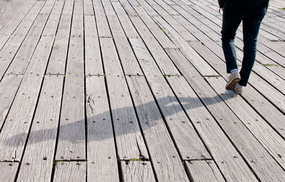 Low section of man standing on wooden floor