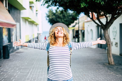 Young woman smiling while standing in front of building