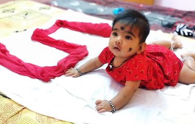 High angle view of baby girl lying on bed