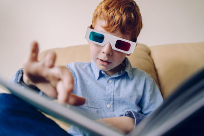 Boy looking at camera while sitting at home