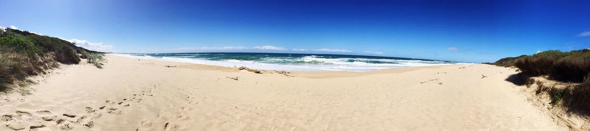 Scenic view of beach against clear blue sky