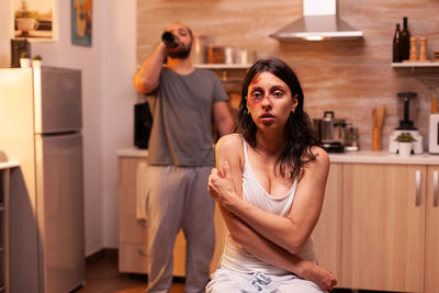 Side view of young woman standing at home