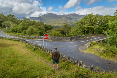 Rear view of man on road against sky
