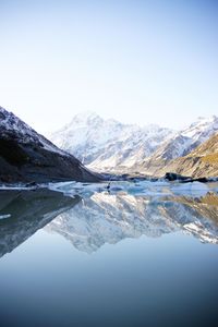 Scenic view of lake by mountains against clear sky