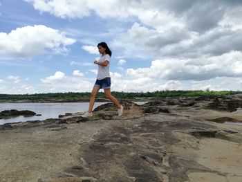 Woman standing on beach against sky