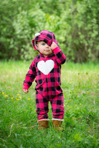 Portrait of cute girl standing on field