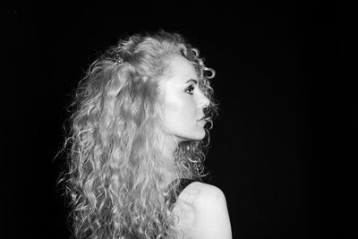 Portrait of a young woman against black background