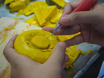 Cropped hands making floral pattern on food