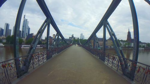 Bridge over river against cloudy sky