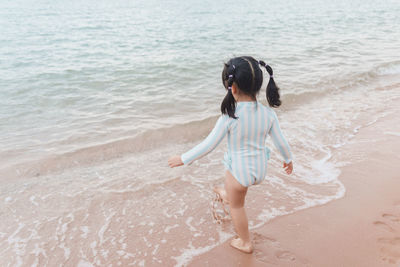 Side view of girl standing at beach