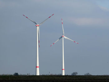 Low angle view of windmill on field against sky