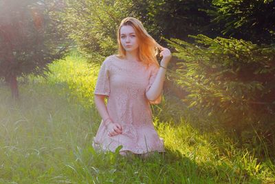 Portrait of beautiful woman standing on grassy field