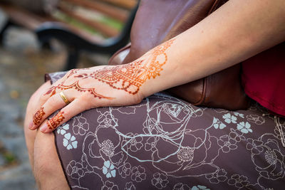 Midsection of woman with henna tattoo