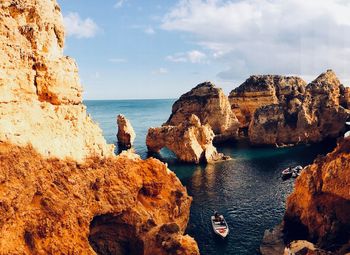 Rock formations by sea against sky