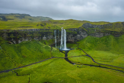 Scenic view of waterfall against sky